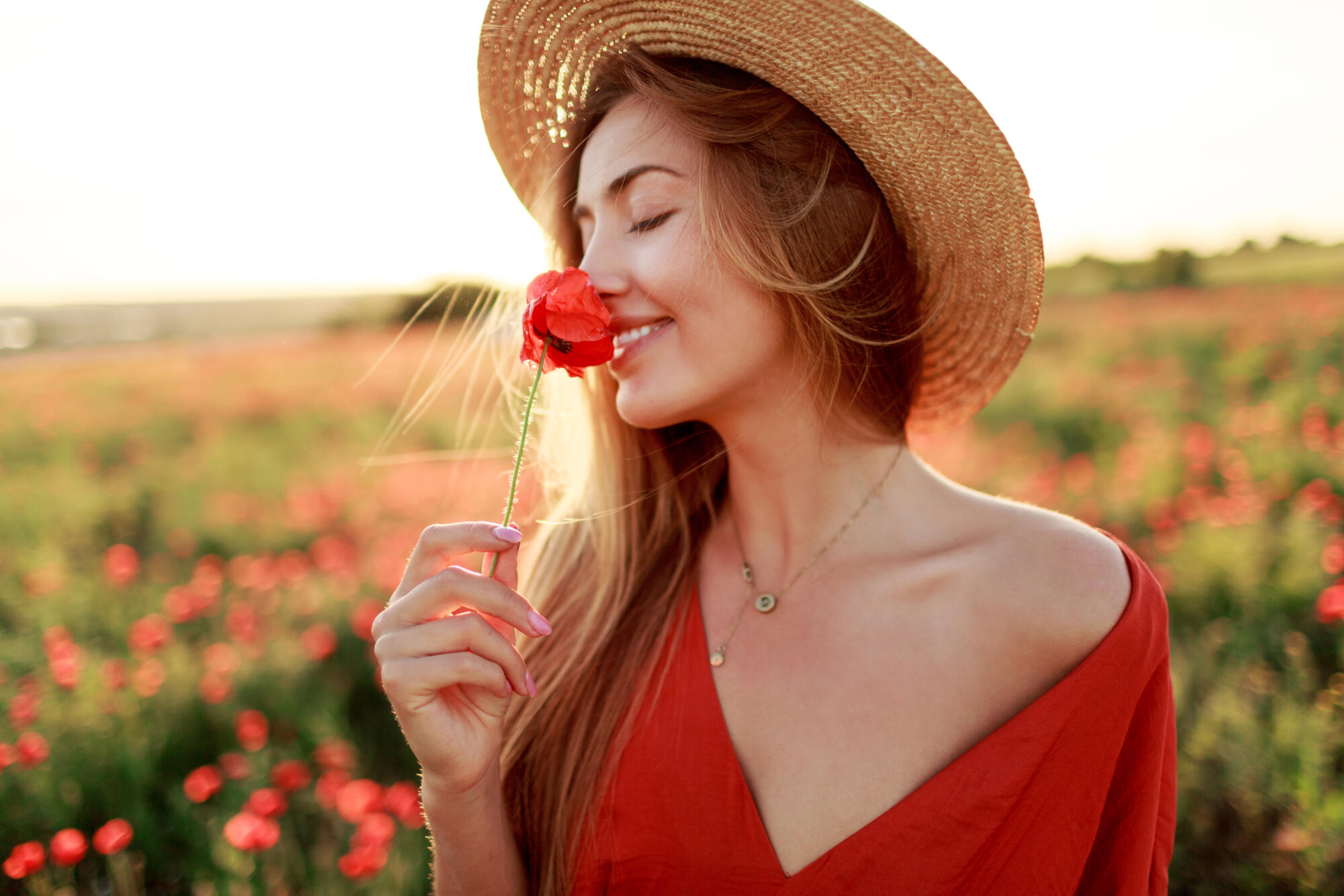 romantic blonde woman with flower hand walking amazing poppy field warm sunset colors straw hat red dress soft colors scaled 1
